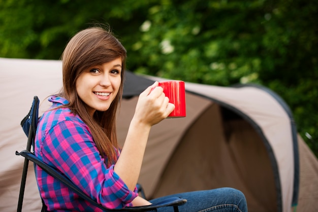 Mujer joven sentada frente a la carpa