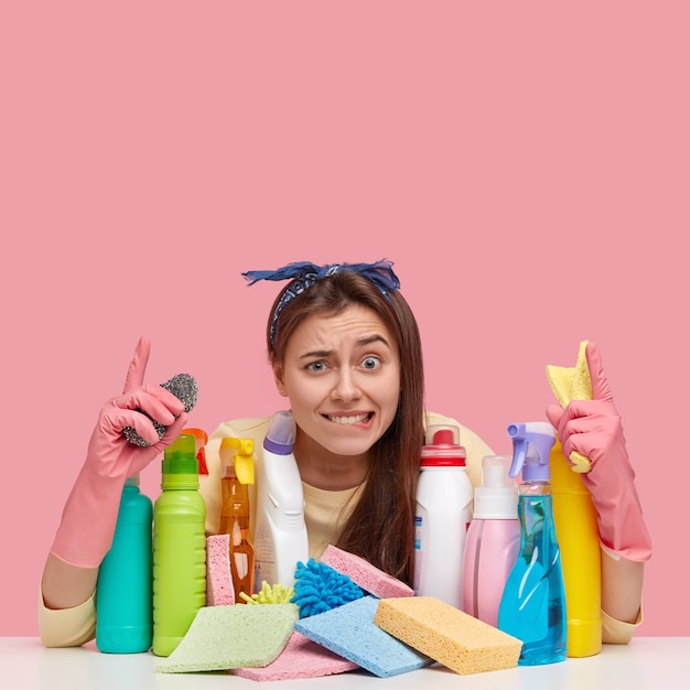 Mujer joven sentada junto a productos de limpieza