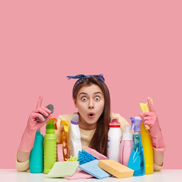 Mujer joven sentada junto a productos de limpieza