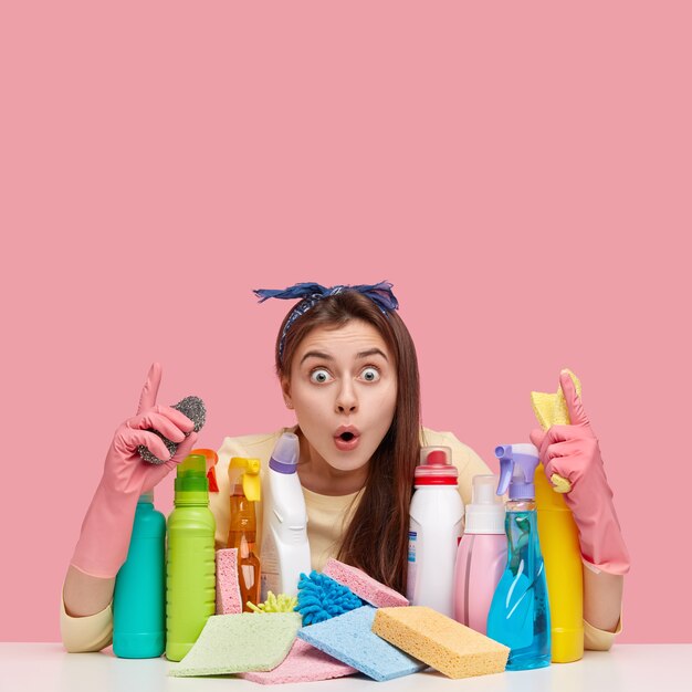 Mujer joven sentada junto a productos de limpieza