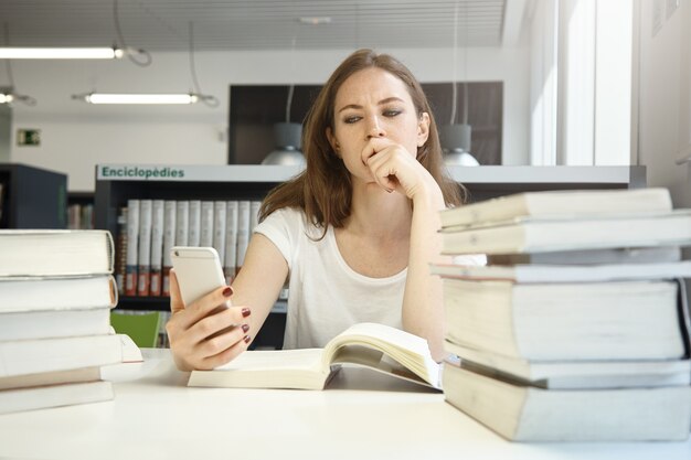 Mujer joven, sentado, en, biblioteca