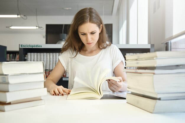 Mujer joven, sentado, en, biblioteca