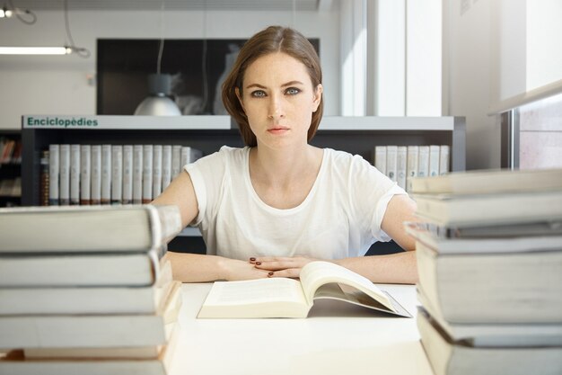 Mujer joven, sentado, en, biblioteca