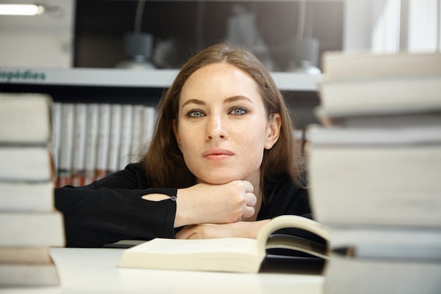 Mujer joven, sentado, en, biblioteca