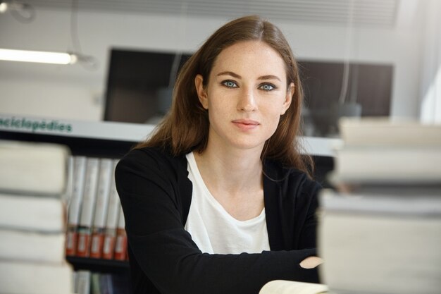 Mujer joven, sentado, en, biblioteca