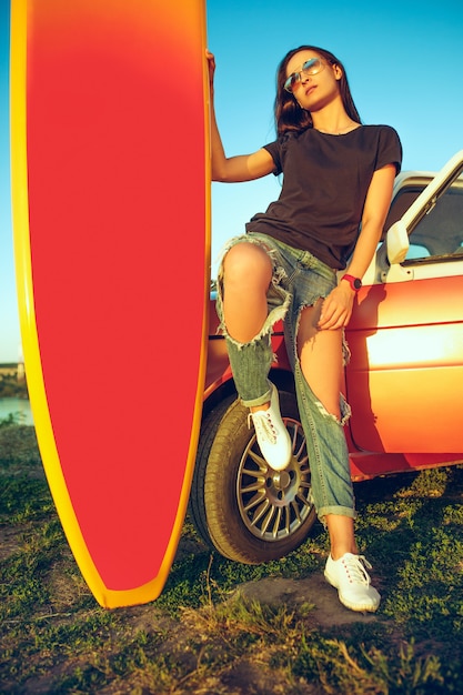 Mujer joven, sentado, en, coche, con, tabla de surf