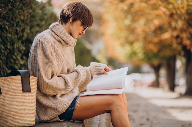 Mujer joven, sentado, en el estacionamiento, y, lectura