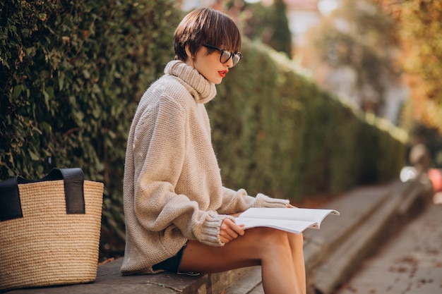 Mujer joven, sentado, en el estacionamiento, y, lectura