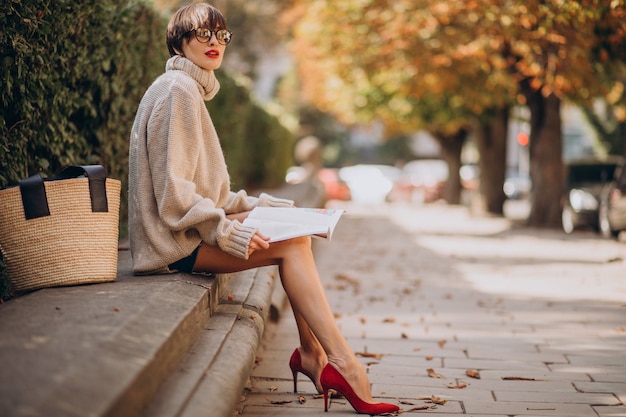 Mujer joven, sentado, en el estacionamiento, y, lectura