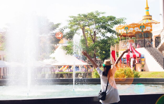 Mujer joven en sentimiento de felicidad con fondo de paseo parque de atracciones