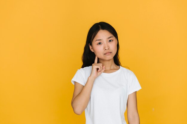 Mujer joven seria con fondo naranja