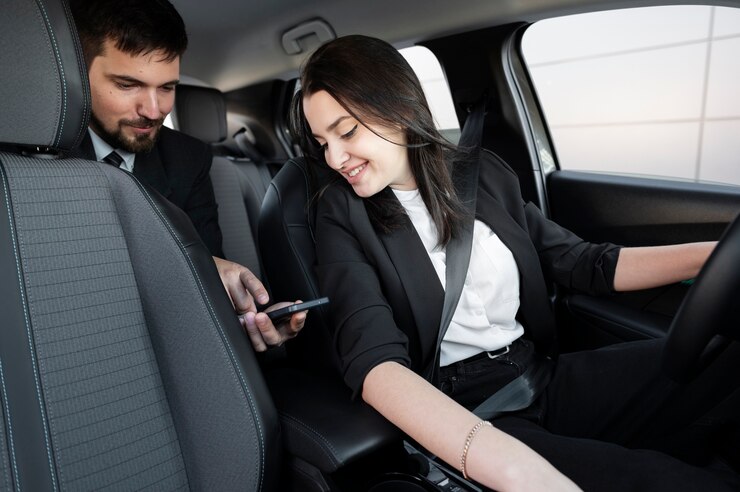 Foto gratuito mujer joven siendo un conductor uber para un cliente masculino