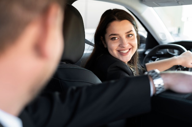 Mujer joven siendo un conductor uber para un cliente masculino