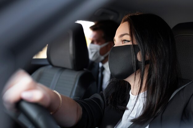 Mujer joven siendo un conductor uber para un cliente masculino