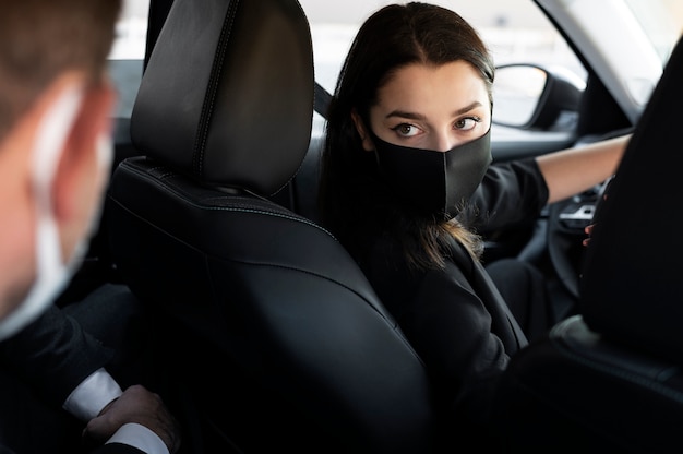 Mujer joven siendo un conductor uber para un cliente masculino