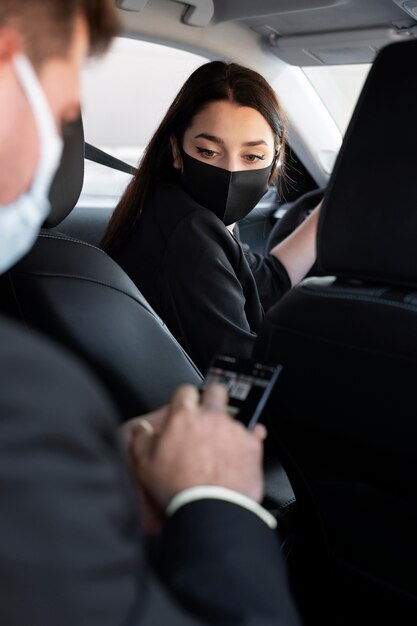 Mujer joven siendo un conductor uber para un cliente masculino