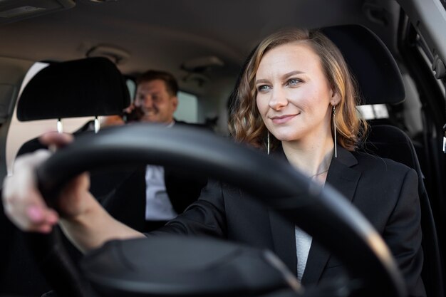 Mujer joven siendo un conductor uber para un cliente masculino