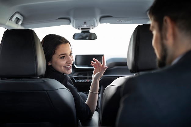 Mujer joven siendo un conductor uber para un cliente masculino