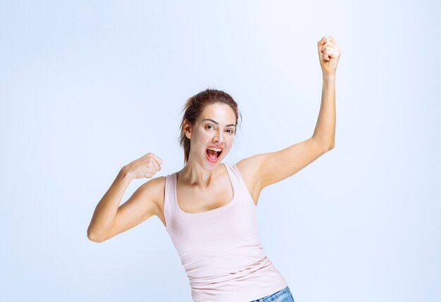 Mujer joven se siente feliz y mostrando signos de mano positivos