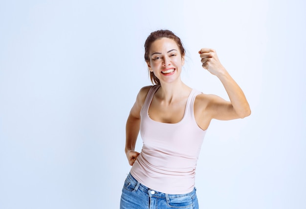 Mujer joven se siente feliz y mostrando signos de mano positivos