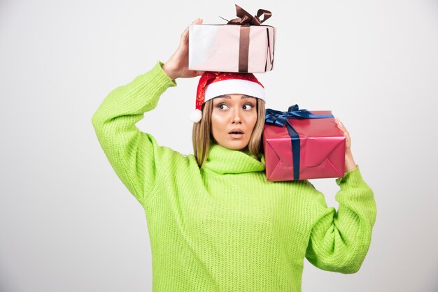Mujer joven con sobrecarga de regalos festivos de Navidad.