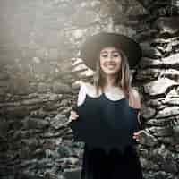 Foto gratuita mujer joven en sombrero de bruja con decoración de halloween