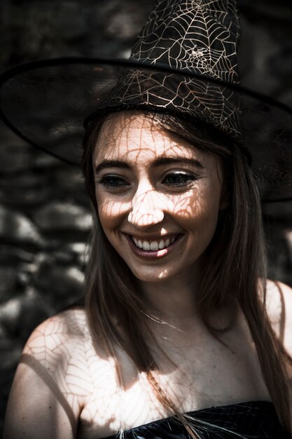 Mujer joven con sombrero de bruja sonriendo