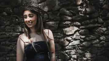 Foto gratuita mujer joven con sombrero de bruja y vestido negro sonriendo