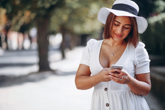 Mujer joven con sombrero hablando por teléfono