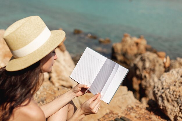 Mujer joven con un sombrero hojeando un cuaderno