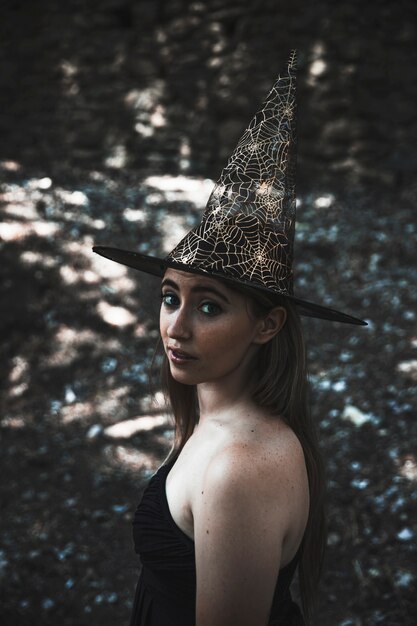 Foto gratuita mujer joven en sombrero de mago mirando a cámara