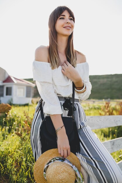 Mujer joven con sombrero de paja en el campo