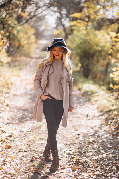 Mujer joven en sombrero en un parque del otoño