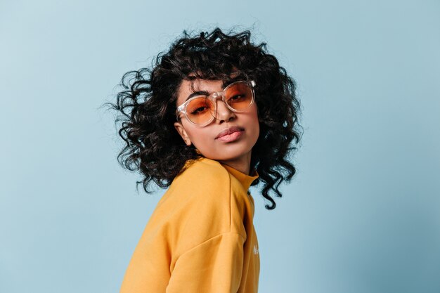 Mujer joven soñadora en gafas de sol mirando al frente