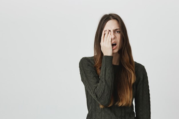 Mujer joven soñolienta facepalm y bostezando exhausto