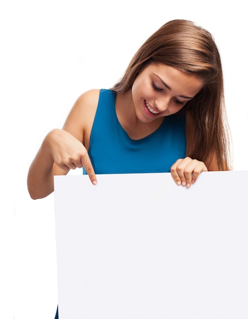 Mujer joven sonriemte mirando un cartel publicitario