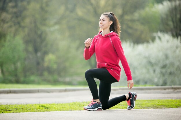 Mujer joven sonriendo antes de comenzar a correr