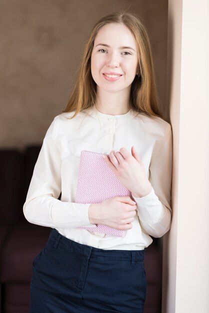 Mujer joven sonriente con un cuaderno