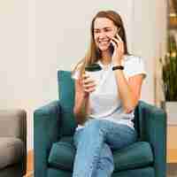 Foto gratuita mujer joven sonriente hablando por teléfono