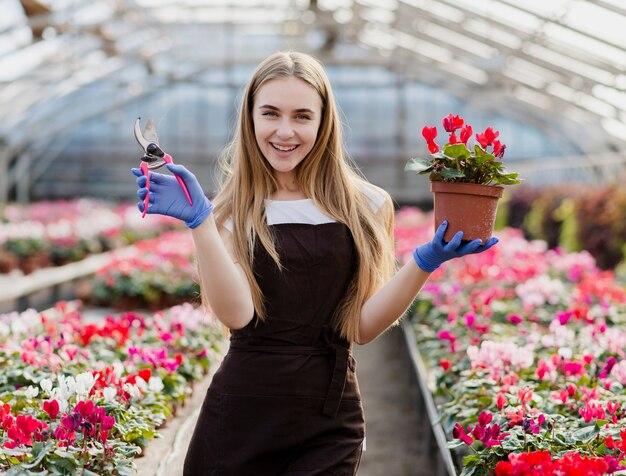Mujer joven sonriente llevando flores