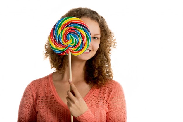 Mujer joven sonriente mostrando una piruleta