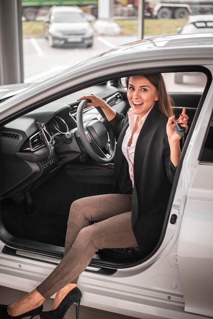 Mujer joven sonriente probando un coche