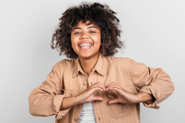 Mujer joven sonriente que hace la muestra del hogar