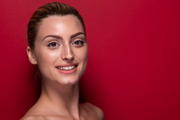 Mujer joven sonriente que mira la cámara