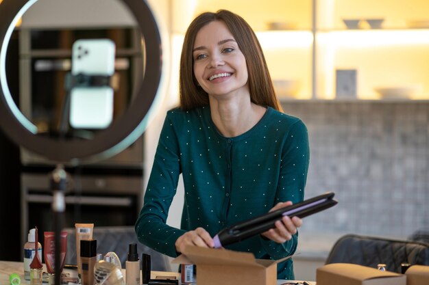 Mujer joven sonriente que muestra consejos sobre el cuidado del cabello y se ve feliz