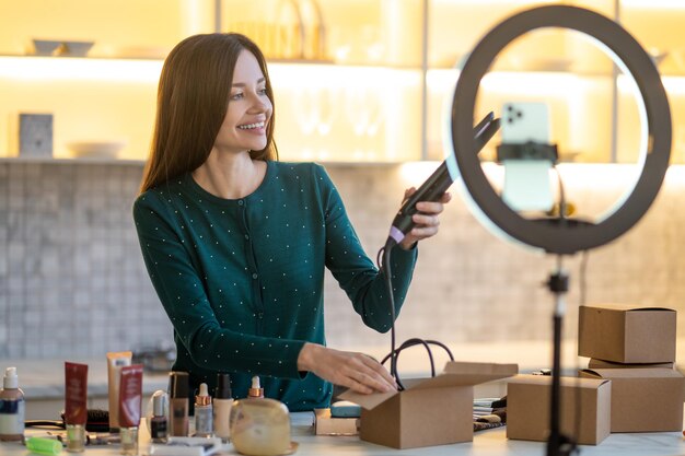 Mujer joven sonriente que muestra consejos sobre el cuidado del cabello y se ve feliz