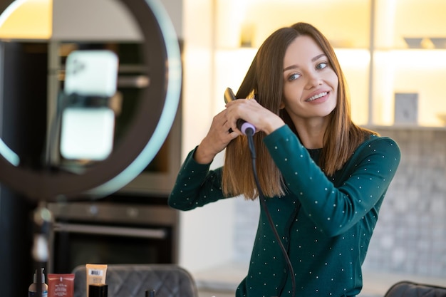 Mujer joven sonriente que muestra consejos sobre el cuidado del cabello