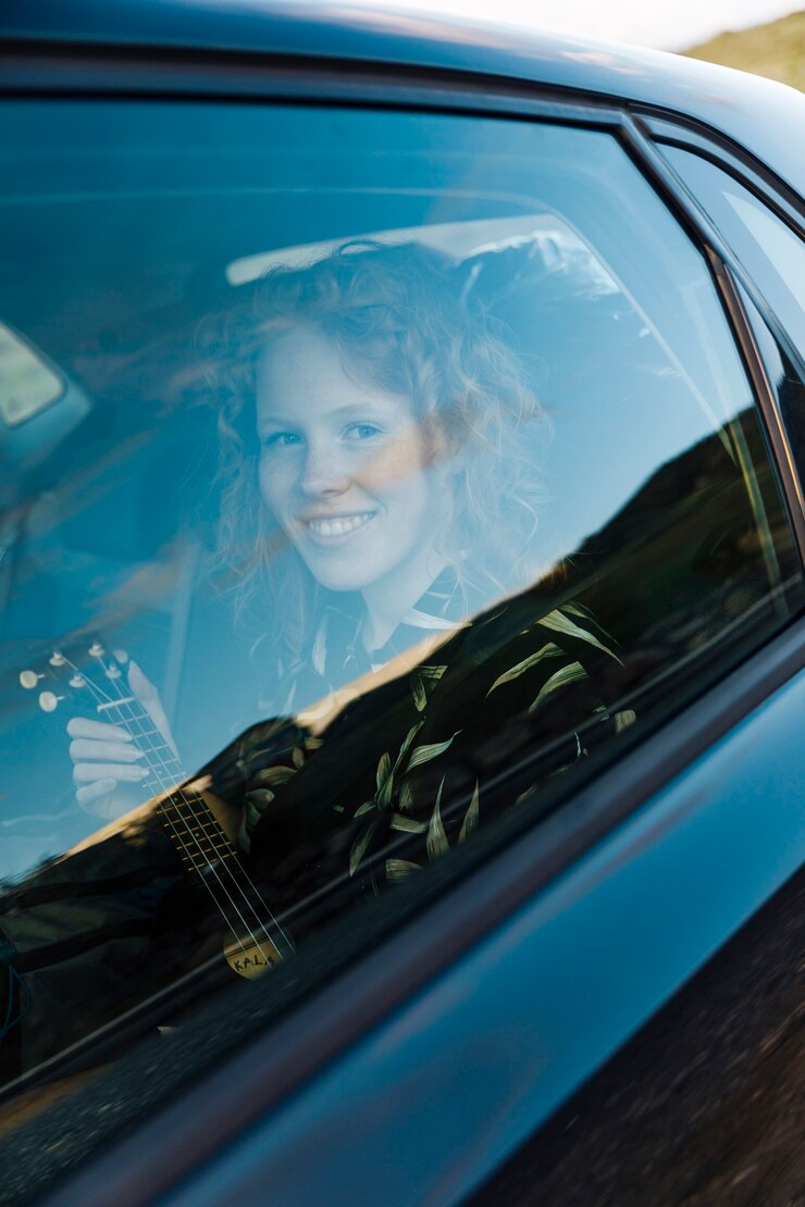 Foto gratuito mujer joven sonriente que se sienta en coche