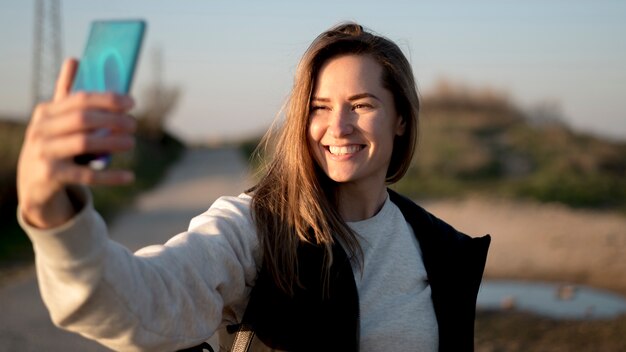 Mujer joven sonriente que toma una foto