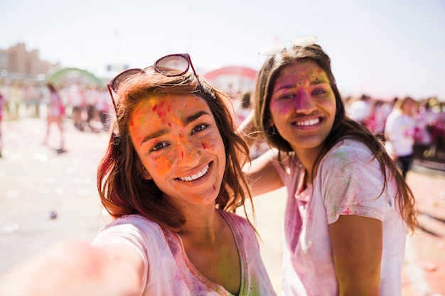 Mujer joven sonriente que toma el selfie con su amigo en holi